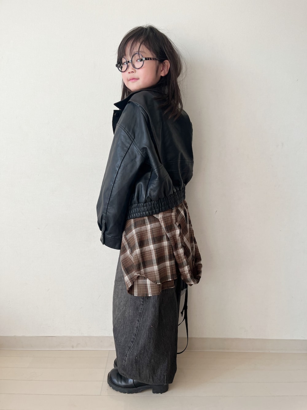 ブラウン系のトップス、ブラック系のデニムパンツ、ブラック系のタンクトップを着用したキッズの冬コーディネートの4枚目の写真