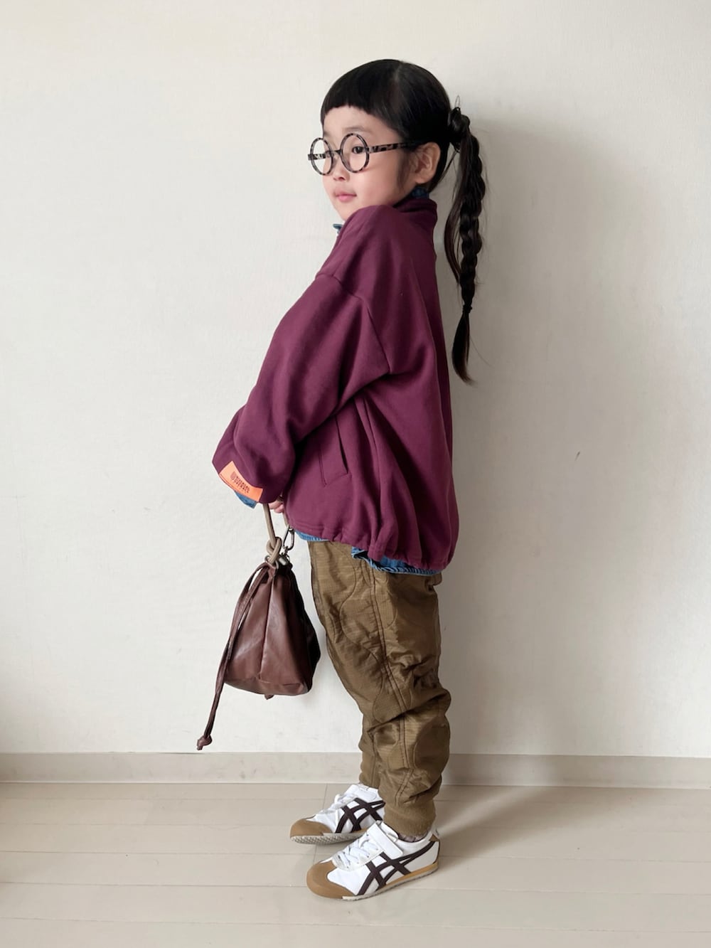 レッド系のスウェット、ブルー系のシャツ/ブラウス、ブラウン系のショルダーバッグを着用したキッズの冬コーディネートの2枚目の写真