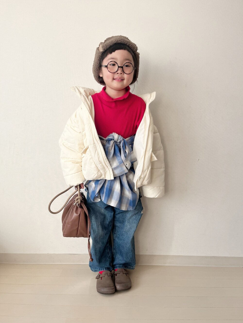 ホワイト系のダウンジャケット/コート、レッド系のTシャツ/カットソー、ブルー系のデニムパンツを着用したキッズの冬コーディネートの2枚目の写真