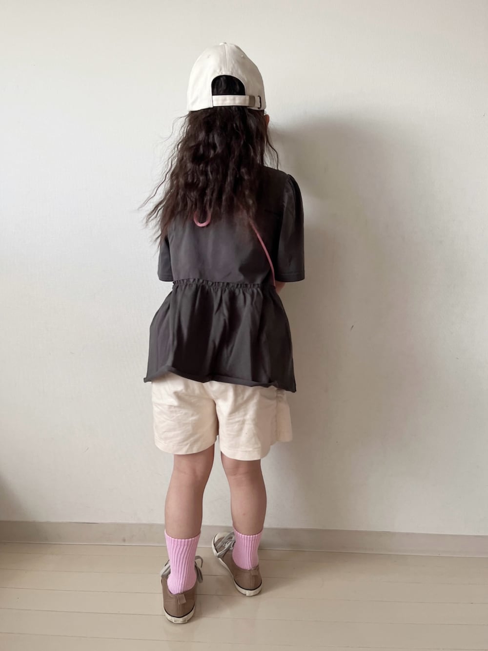 グレー系のワンピース、ホワイト系のその他パンツ、ピンク系のハンドバッグを着用したキッズの春コーディネートの4枚目の写真