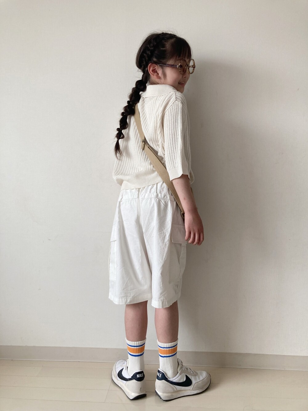 ホワイト系のカーゴパンツ、ホワイト系のカーディガン/ボレロ、ベージュ系のショルダーバッグを着用したキッズの春コーディネートの2枚目の写真