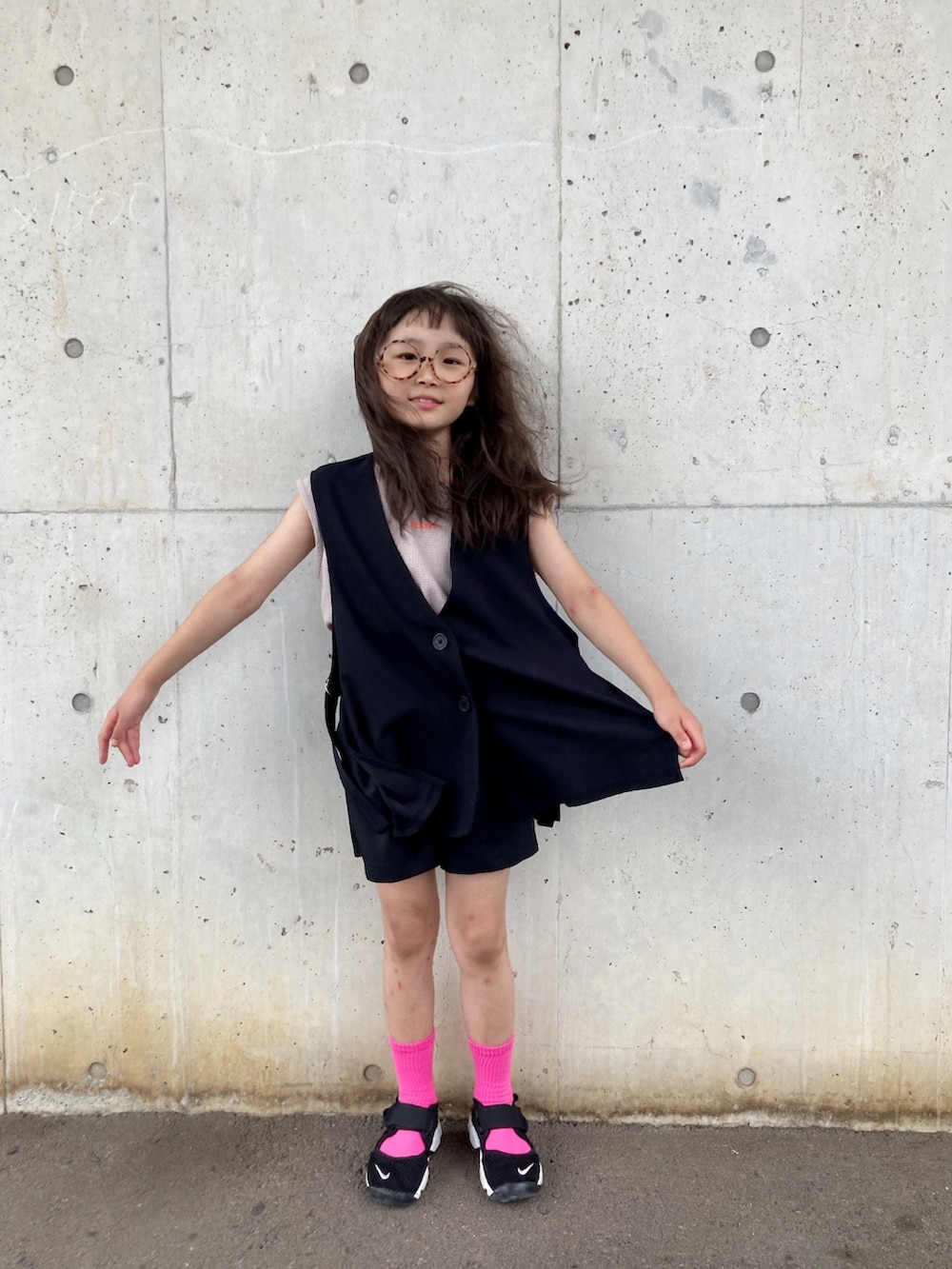 グレー系のタンクトップ、グレー系のベスト、ブラック系のスニーカーを着用したキッズの秋コーディネートの3枚目の写真