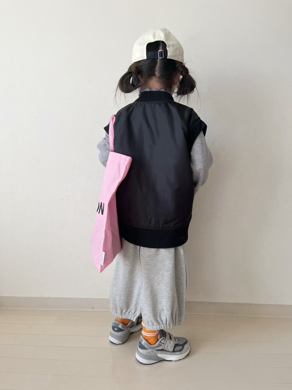 グレー系のTシャツ/カットソー、グレー系のスカート、ブラック系のMA-1を着用したキッズの冬コーディネートの3枚目の写真