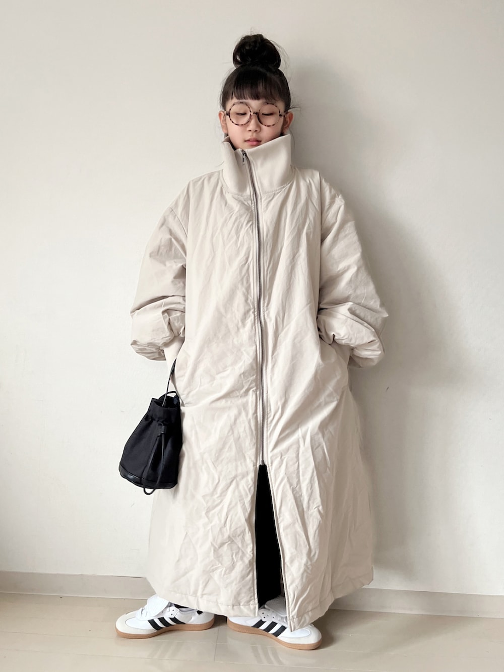 ホワイト系のナイロンジャケット、グレー系のその他パンツ、ホワイト系のスニーカーを着用したキッズの秋コーディネートの2枚目の写真