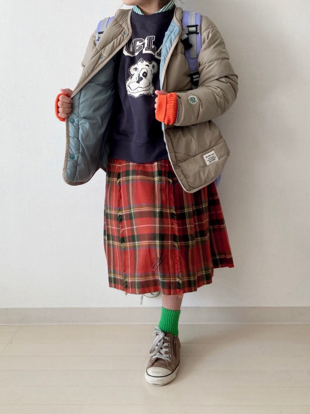 ブラウン系のブルゾン、グレー系のスウェット、レッド系のスカートを着用したキッズの秋コーディネートの4枚目の写真