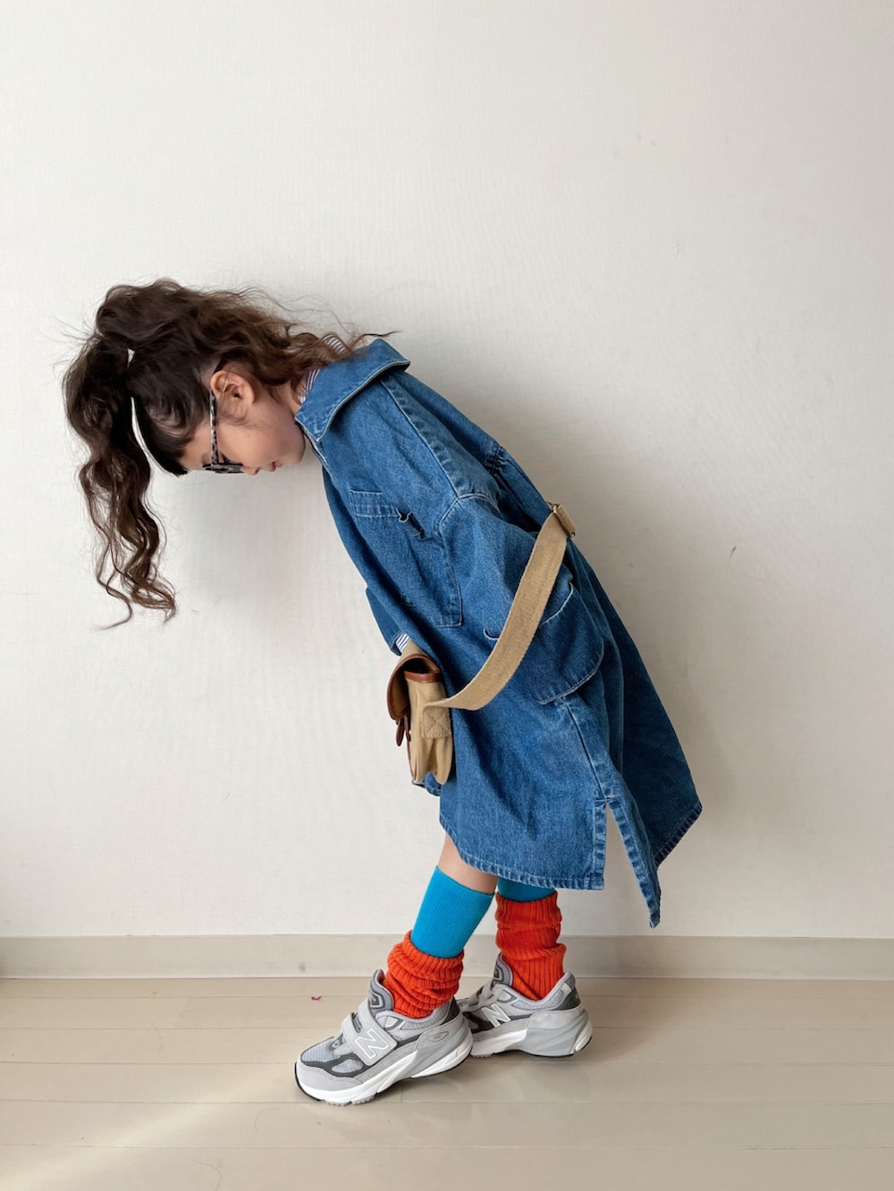 ブルー系のワンピース、ブルー系のシャツ/ブラウス、ベージュ系のショルダーバッグを着用したキッズの冬コーディネートの3枚目の写真