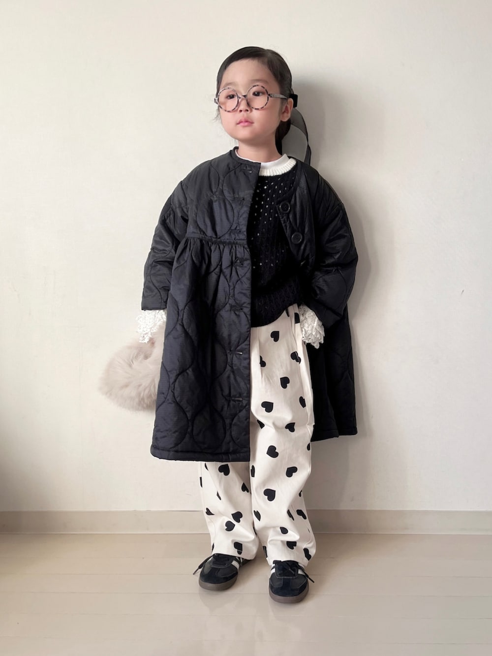 ブラック系のミリタリージャケット、ブラック系のニット/セーター、ホワイト系のTシャツ/カットソーを着用したキッズの秋コーディネートの5枚目の写真