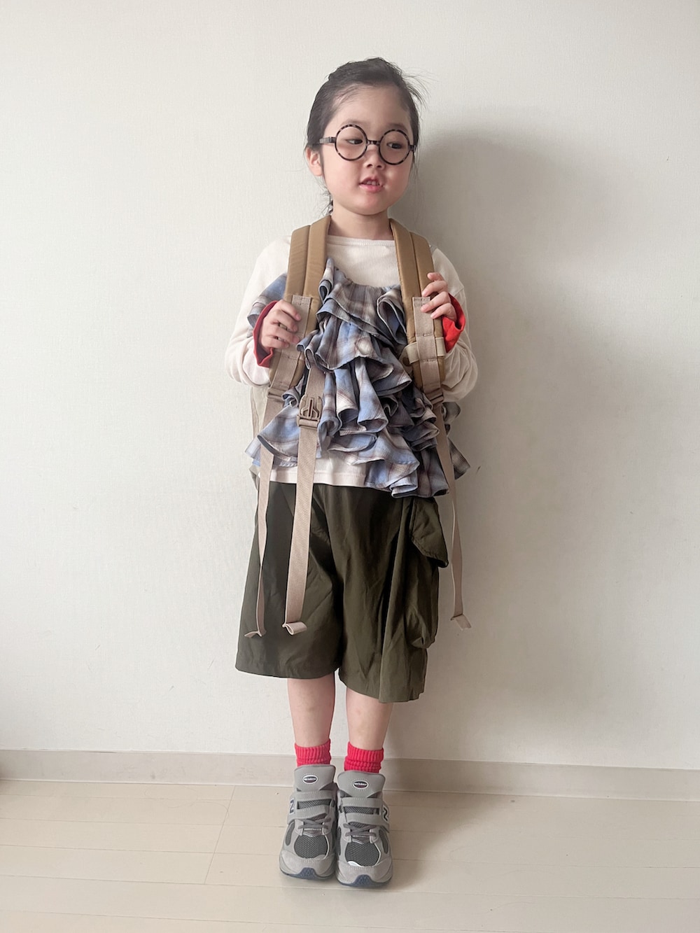 ベージュ系のTシャツ/カットソー、ブルー系のキャミソール、グリーン系のカーゴパンツを着用したキッズの秋コーディネートの2枚目の写真