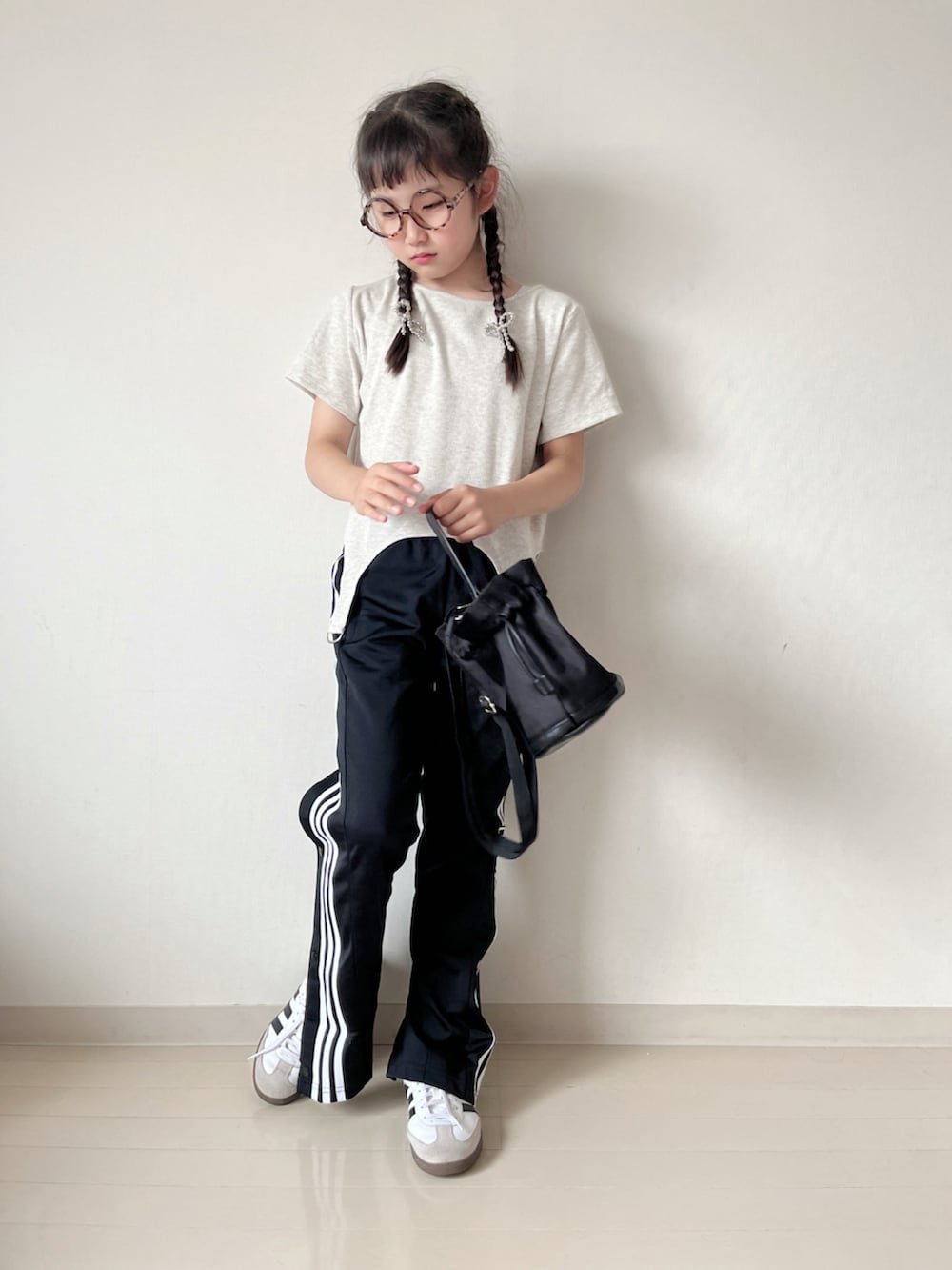 ベージュ系のTシャツ/カットソー、ブラック系のその他パンツ、ホワイト系のスニーカーを着用したキッズの夏コーディネートの4枚目の写真