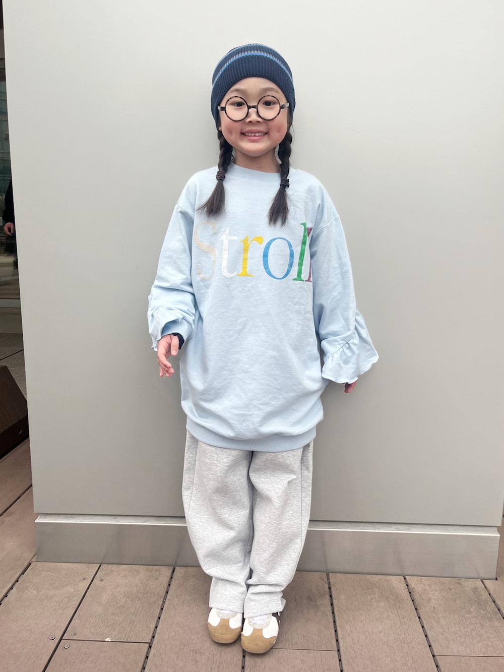 ブルー系のワンピース、グレー系のスウェットパンツ、ホワイト系のスニーカーを着用したキッズの春コーディネートの4枚目の写真