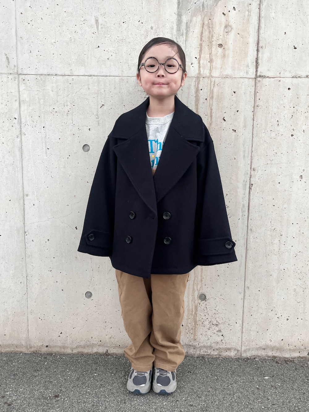 グレー系のTシャツ/カットソー、ブルー系のピーコート、ブラウン系のサロペット/オーバーオールを着用したキッズの秋コーディネートの4枚目の写真