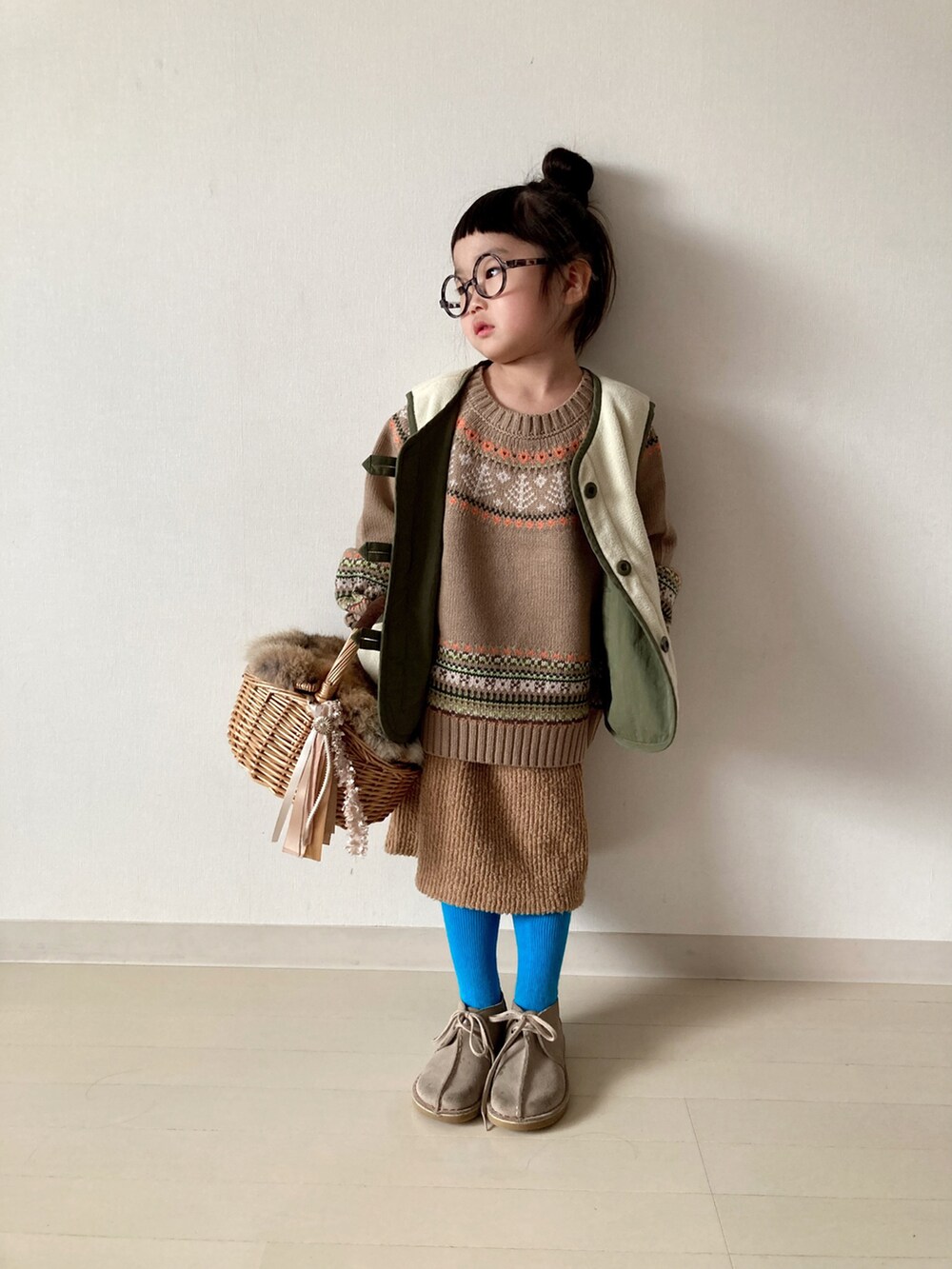 ベージュ系のニット/セーター、グリーン系のベスト、ベージュ系のTシャツ/カットソーを着用したキッズの冬コーディネートの3枚目の写真