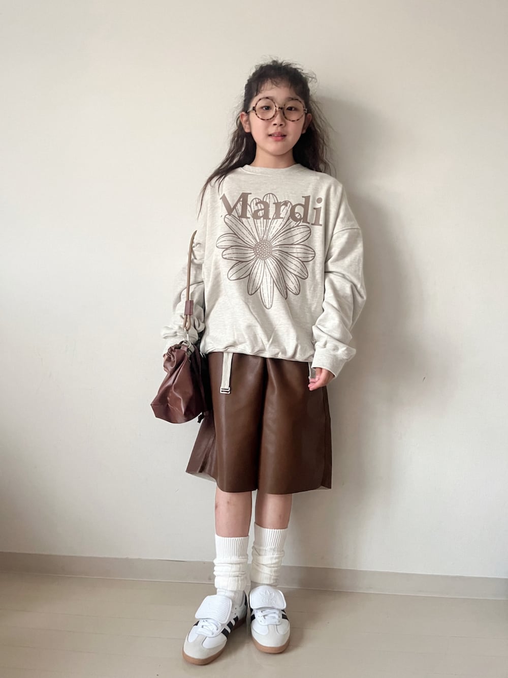 ベージュ系のスウェット、グリーン系のTシャツ/カットソー、ブラウン系のショルダーバッグを着用したキッズの秋コーディネートの3枚目の写真