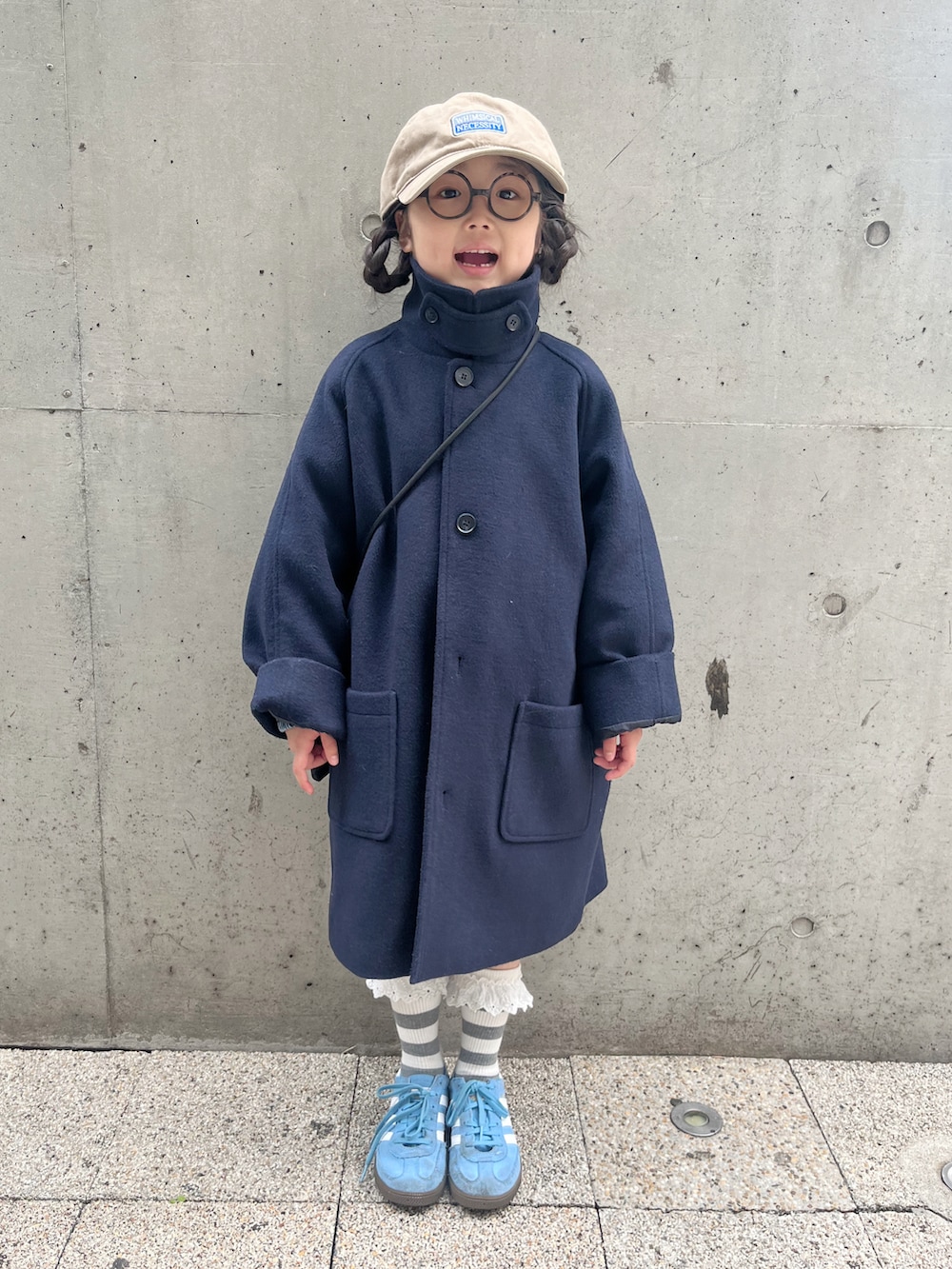 ブルー系のその他アウター、ブルー系のスニーカー、ブラック系のショルダーバッグを着用したキッズの春コーディネートの2枚目の写真