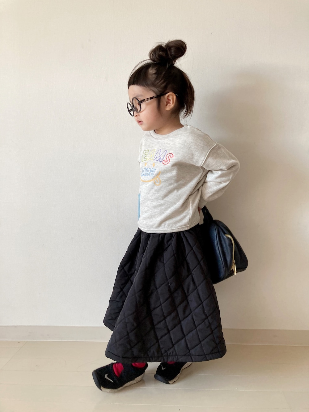 ホワイト系のスウェット、ブラック系のワンピース、ブラック系のスニーカーを着用したキッズの秋コーディネートの5枚目の写真