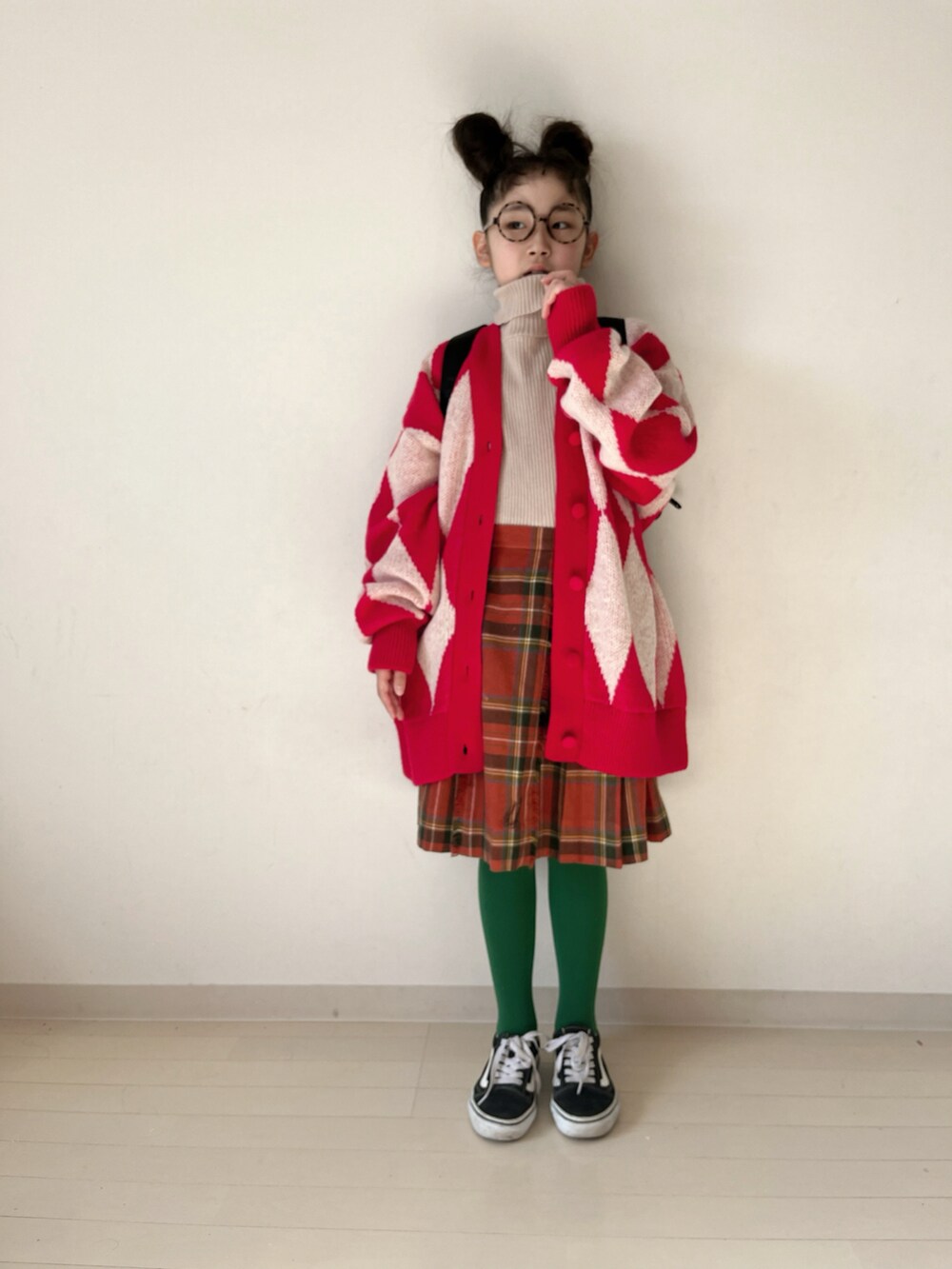 レッド系のカーディガン/ボレロ、レッド系のスカート、ブラック系のスニーカーを着用したキッズの冬コーディネートの4枚目の写真