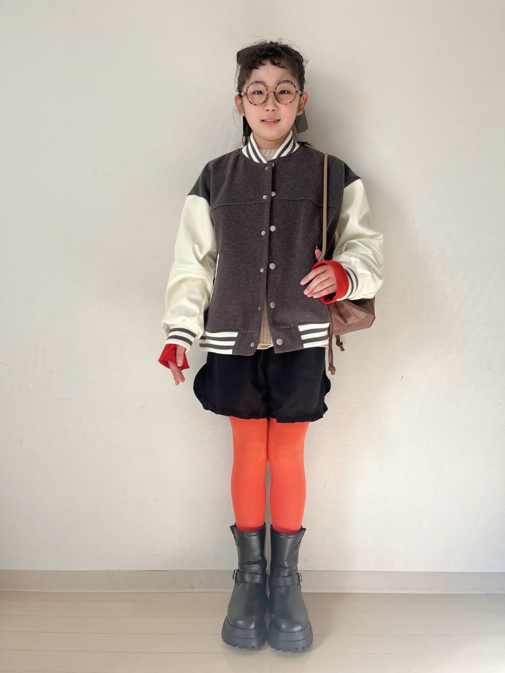 ホワイト系のニット/セーター、ホワイト系のTシャツ/カットソー、グレー系のスタジャンを着用したキッズの秋コーディネートの4枚目の写真