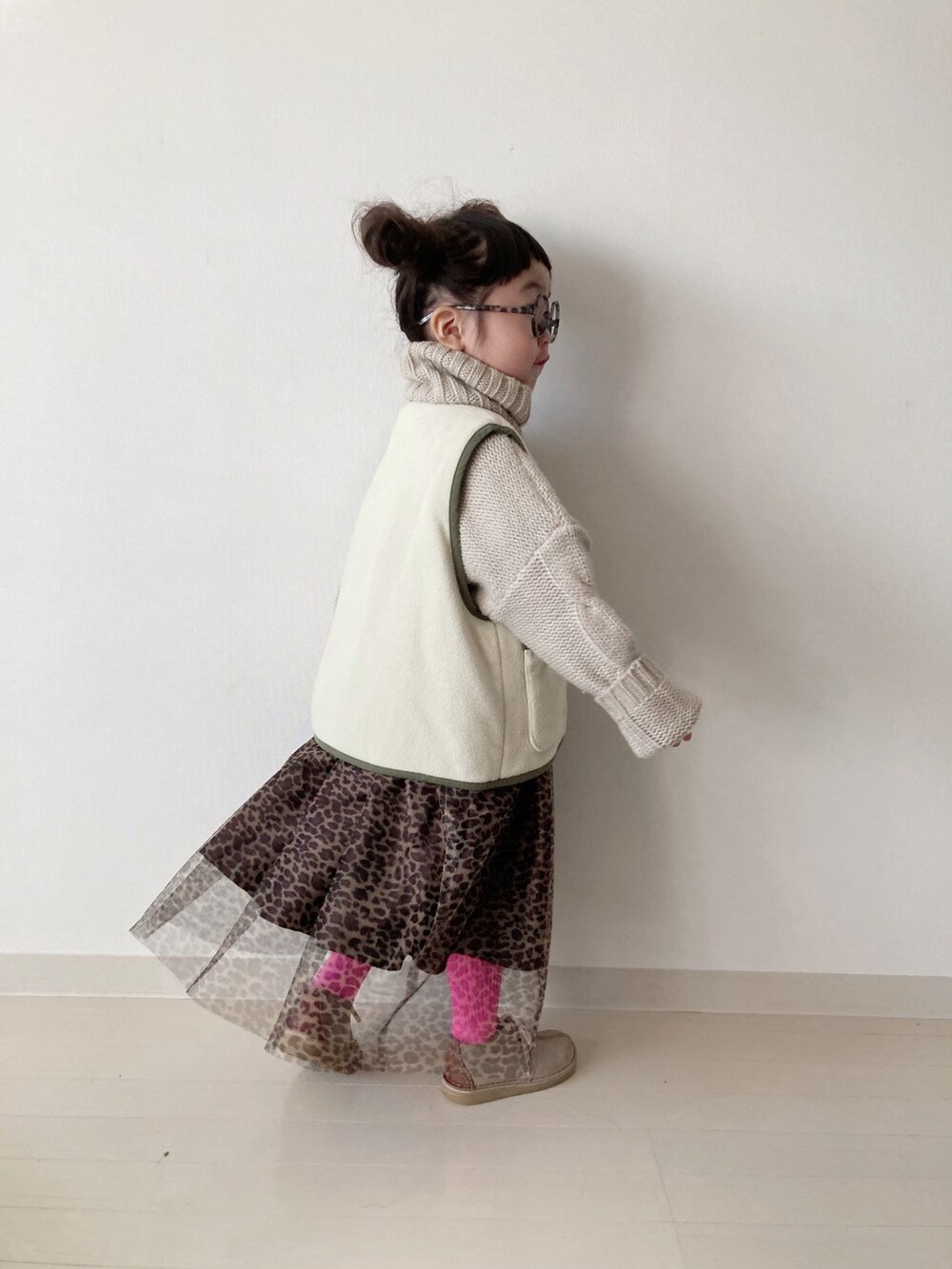 ブラウン系のスカート、グリーン系のベスト、ベージュ系のニット/セーターを着用したキッズの秋コーディネートの5枚目の写真