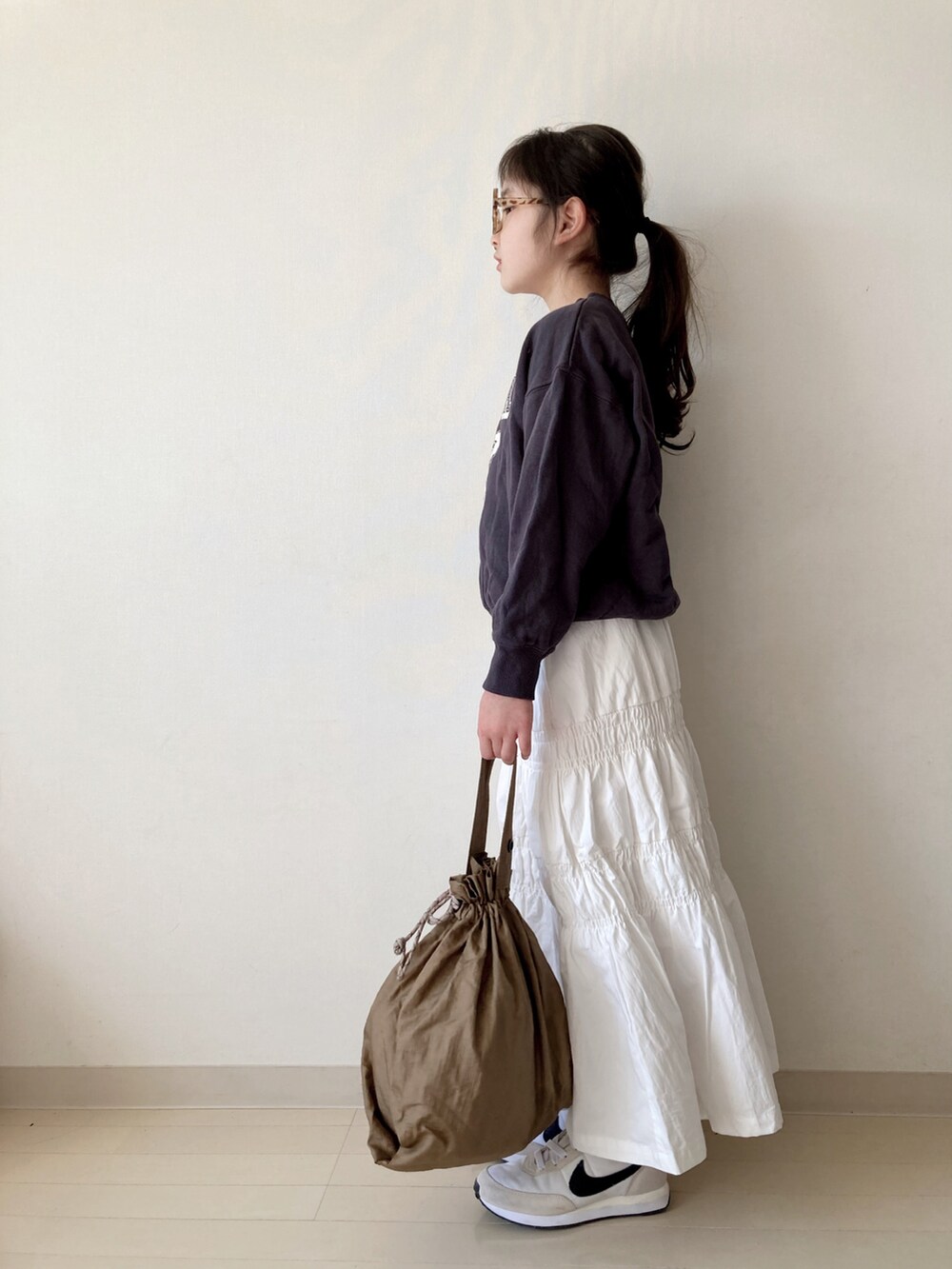 ホワイト系のスカート、グレー系のスウェット、ベージュ系のエコバッグ/サブバッグを着用したキッズの春コーディネートの2枚目の写真