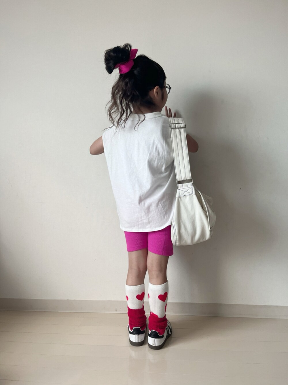 ホワイト系のタンクトップ、ホワイト系のショルダーバッグ、ホワイト系のスニーカーを着用したキッズの夏コーディネートの3枚目の写真