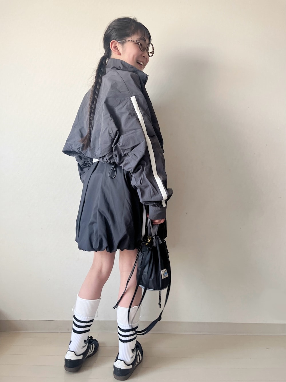 ブラック系のスカート、ブラック系のスニーカー、ブラック系のショルダーバッグを着用したキッズの春コーディネートの4枚目の写真