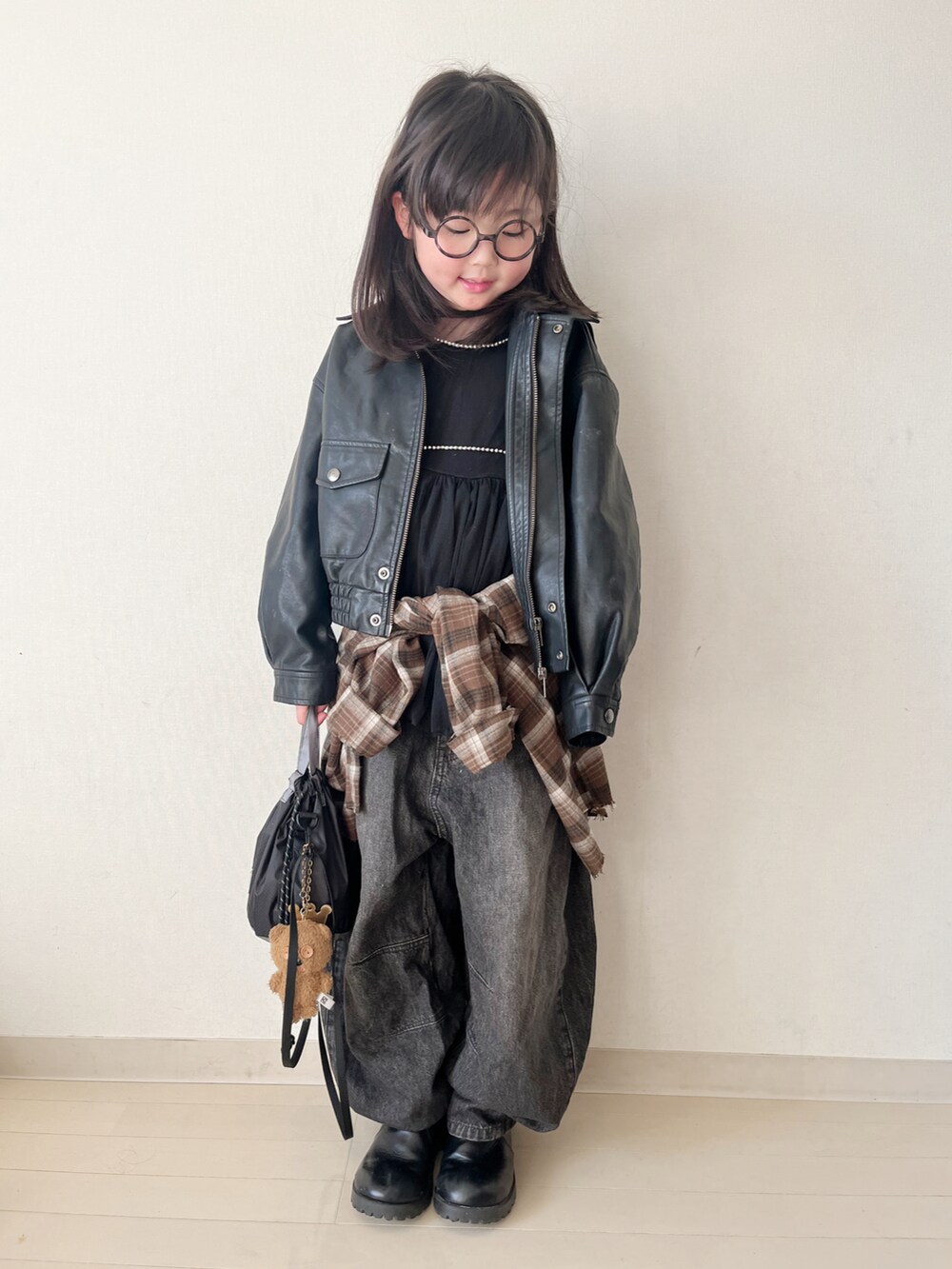ブラウン系のトップス、ブラック系のデニムパンツ、ブラック系のタンクトップを着用したキッズの冬コーディネートの3枚目の写真