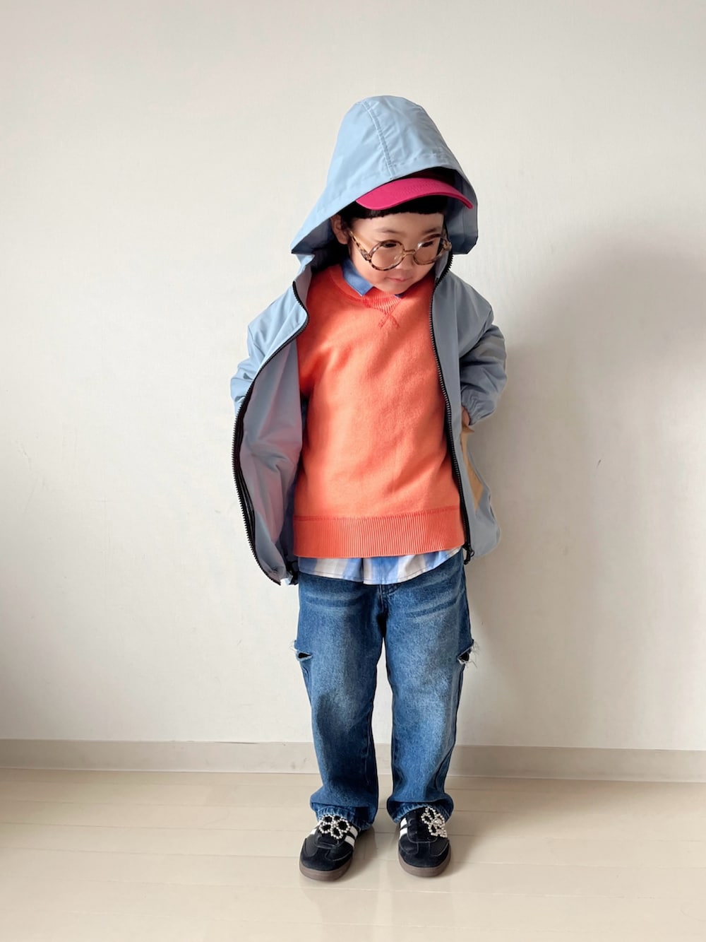ブルー系のナイロンジャケット、オレンジ系のニット/セーター、ブルー系のデニムパンツを着用したキッズの秋コーディネートの2枚目の写真