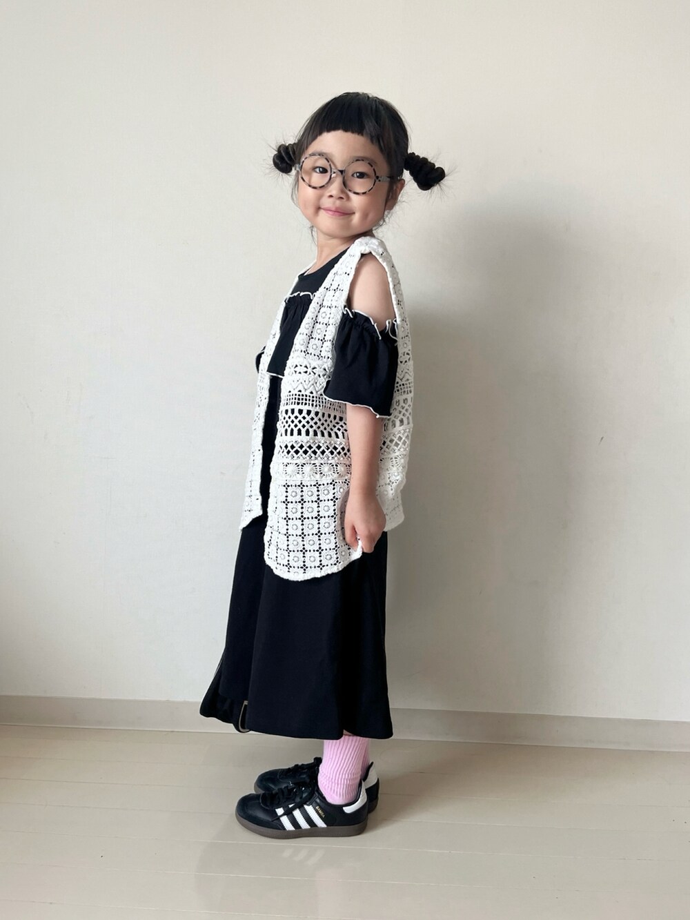ブラック系のワンピース、ホワイト系のベスト、ホワイト系のハンドバッグを着用したキッズの春コーディネートの4枚目の写真