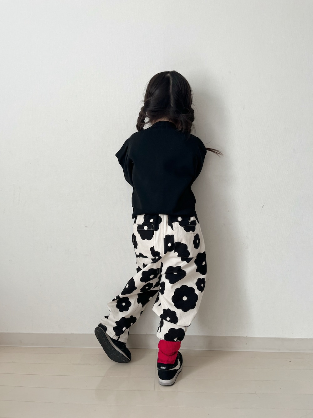 ホワイト系のその他パンツ、ブラック系のカーディガン/ボレロ、ブラック系のスニーカーを着用したキッズの冬コーディネートの5枚目の写真