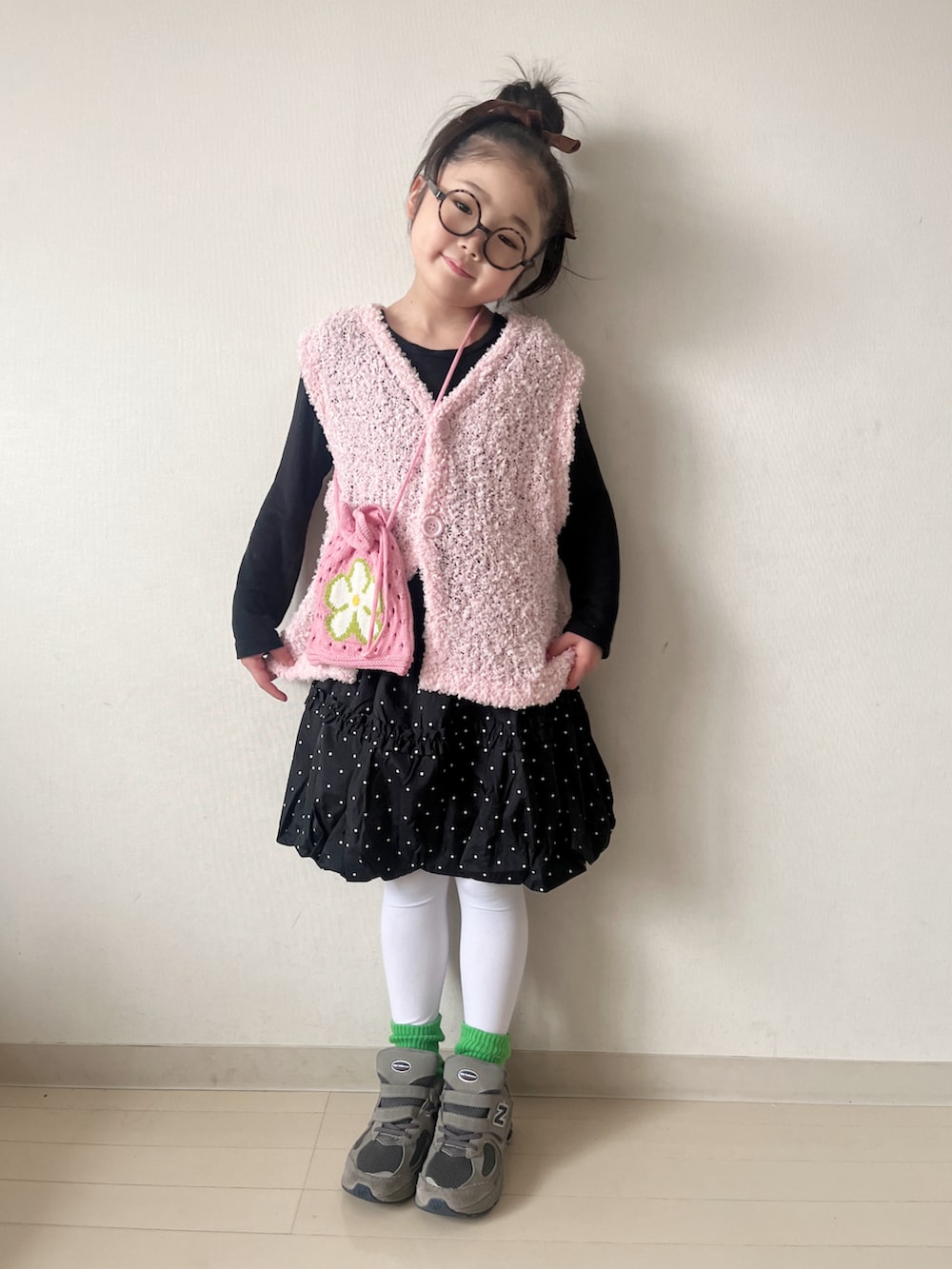 ピンク系のニット/セーター、ブラック系のスカート、グレー系のスニーカーを着用したキッズの冬コーディネートの3枚目の写真