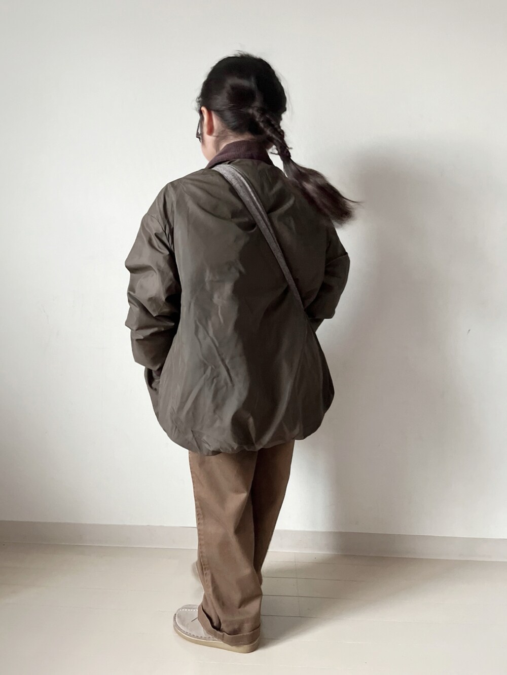 グリーン系のブルゾン、ホワイト系のTシャツ/カットソー、ブラウン系のショルダーバッグを着用したキッズの秋コーディネートの5枚目の写真