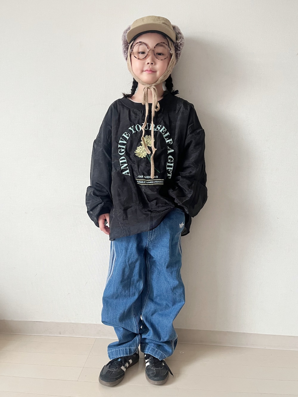 ブラウン系のワンピース、ブラック系のスニーカー、ブラック系のTシャツ/カットソーを着用したキッズの秋コーディネートの3枚目の写真