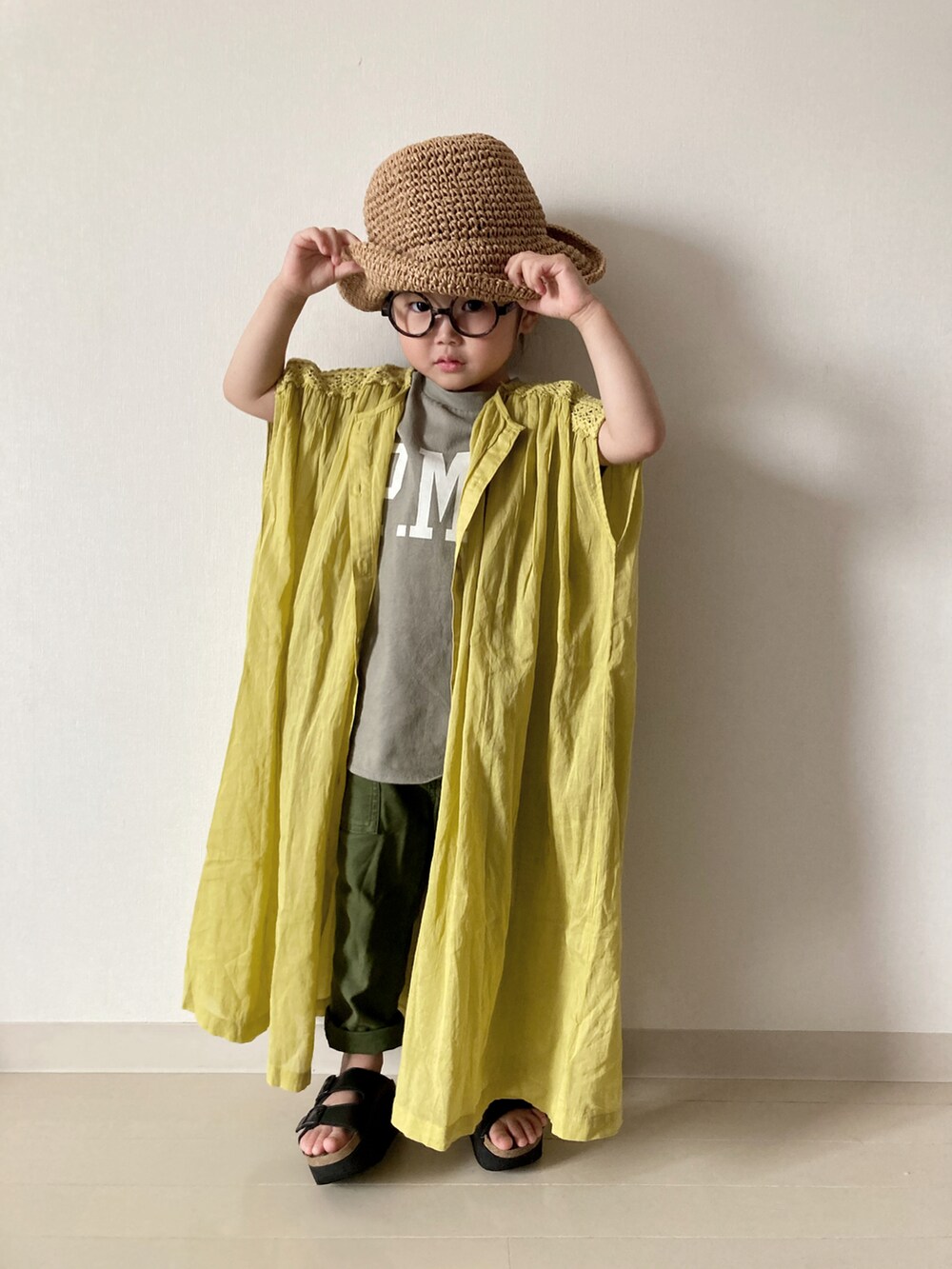 イエロー系のワンピース、グリーン系のTシャツ/カットソー、レッド系のかごバッグを着用したキッズの春コーディネートの2枚目の写真