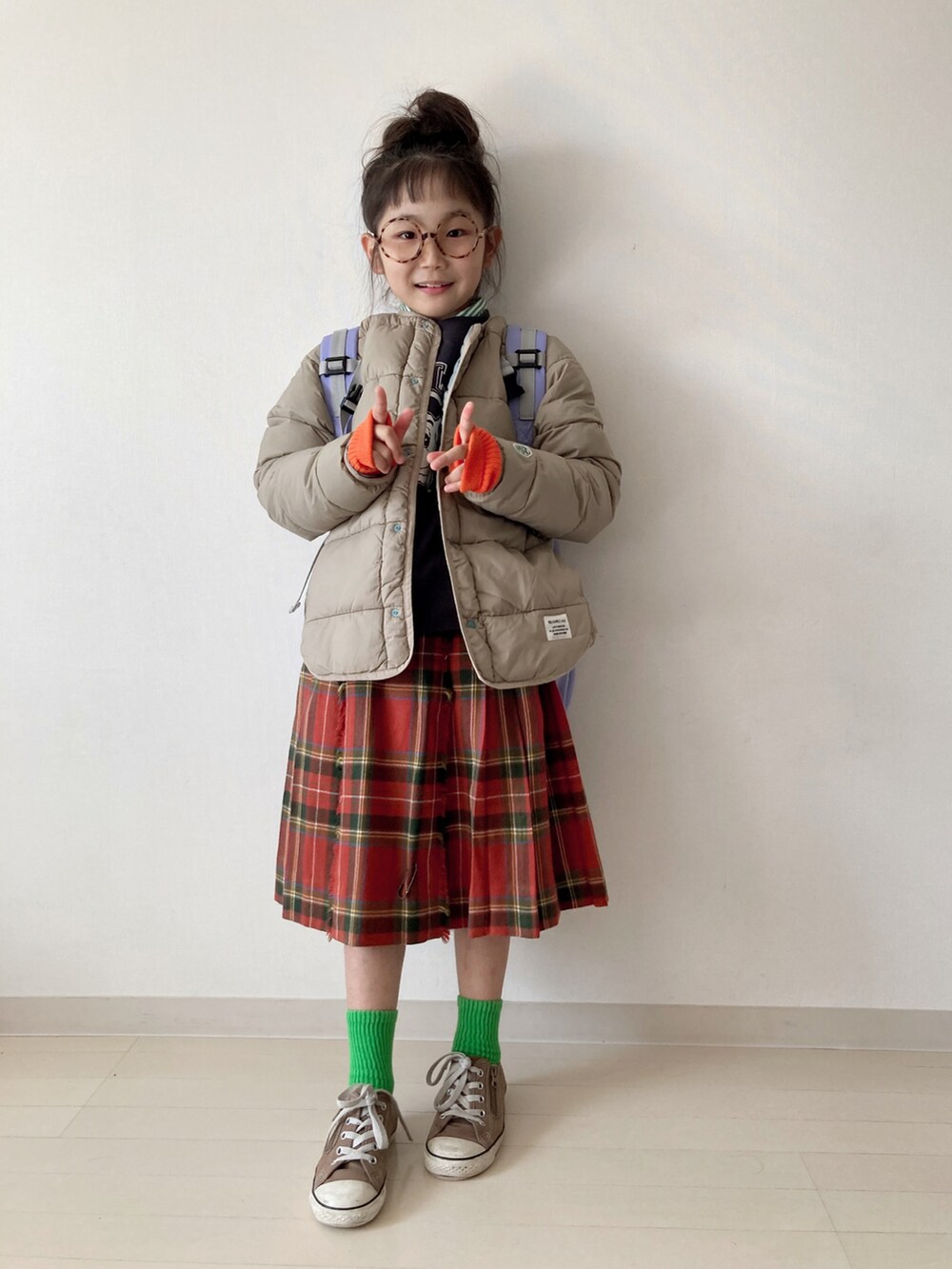 ブラウン系のブルゾン、グレー系のスウェット、レッド系のスカートを着用したキッズの秋コーディネートの3枚目の写真