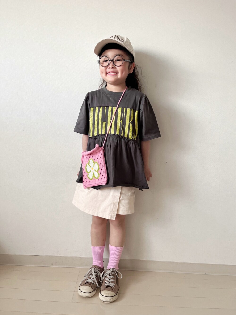 グレー系のワンピース、ホワイト系のその他パンツ、ピンク系のハンドバッグを着用したキッズの春コーディネートの2枚目の写真