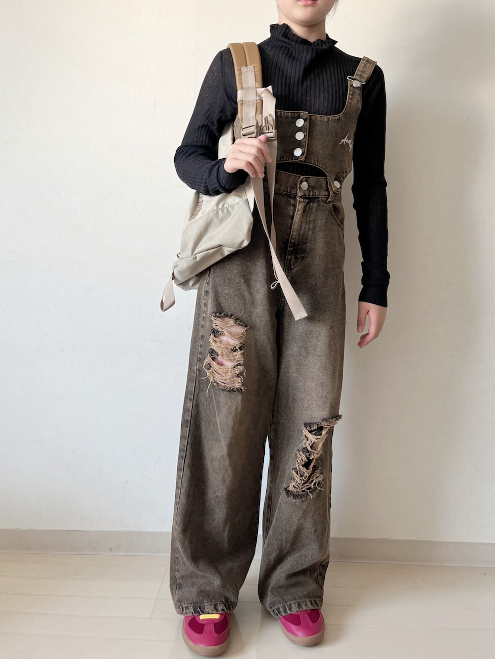 ブラック系のサロペット/オーバーオール、レッド系のスニーカー、ブラック系のニット/セーターを着用したキッズの秋コーディネートの3枚目の写真