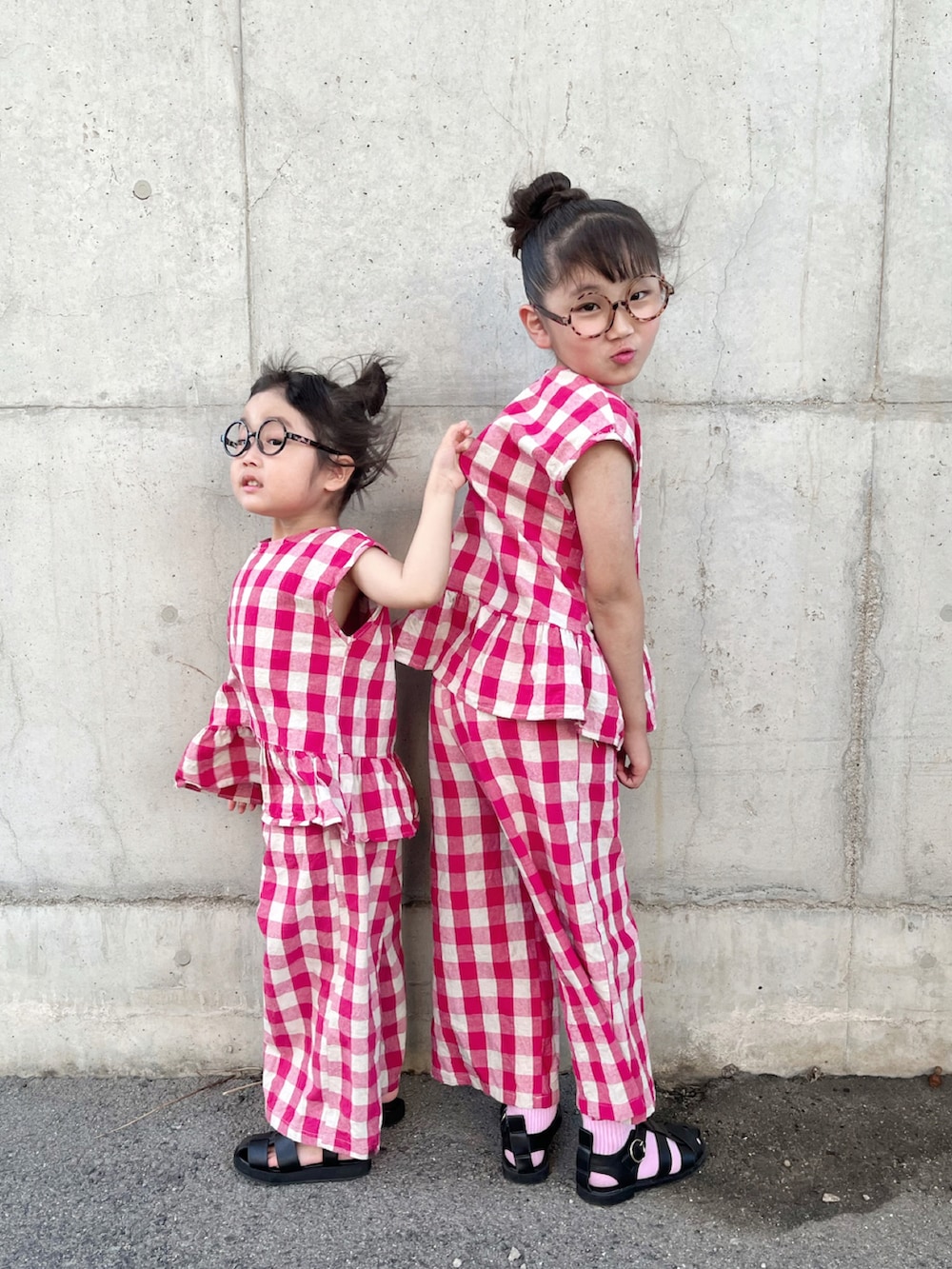 レッド系のセットアップ、レッド系のセットアップ、ブラック系のサンダルを着用したキッズの夏コーディネートの2枚目の写真