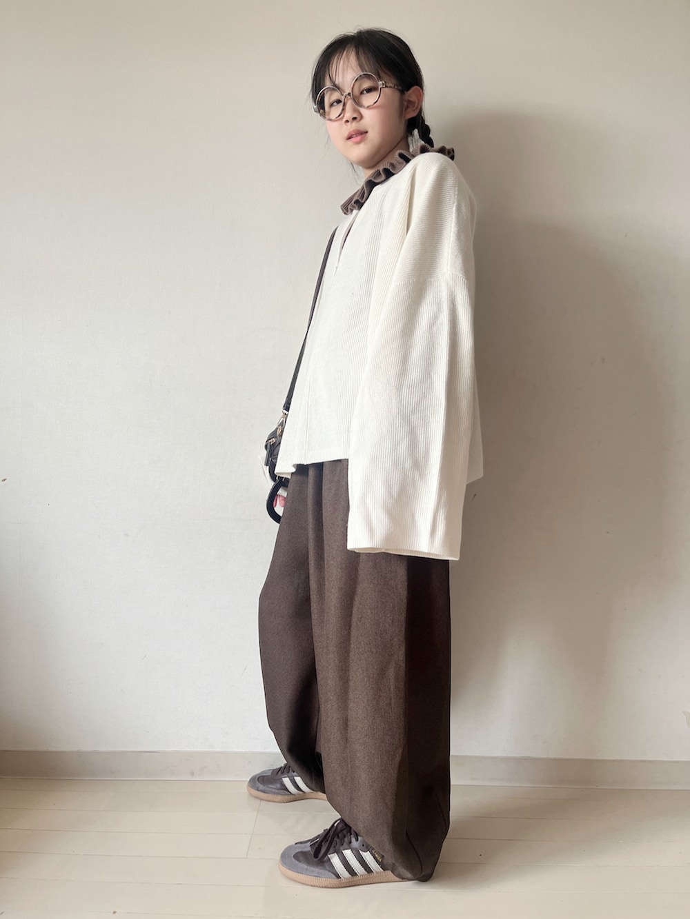 ホワイト系のニット/セーター、ブラウン系のその他パンツ、ブラウン系のハンドバッグを着用したキッズの冬コーディネートの2枚目の写真