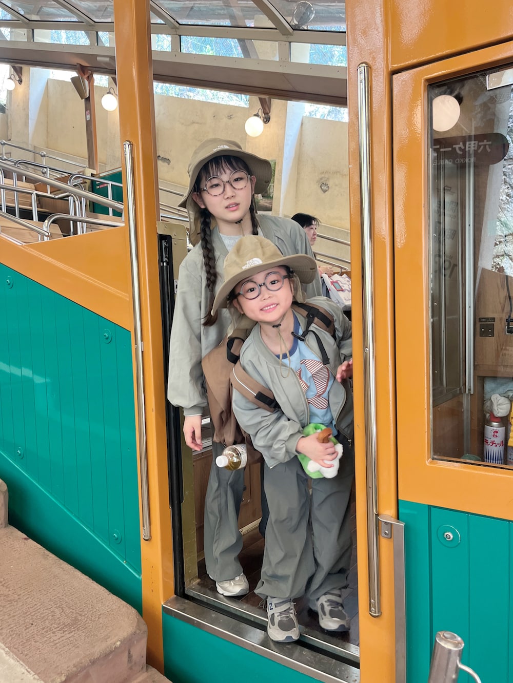 ブルー系のTシャツ/カットソー、ベージュ系のバックパック/リュック、グリーン系のブルゾンを着用したキッズの春コーディネートの2枚目の写真