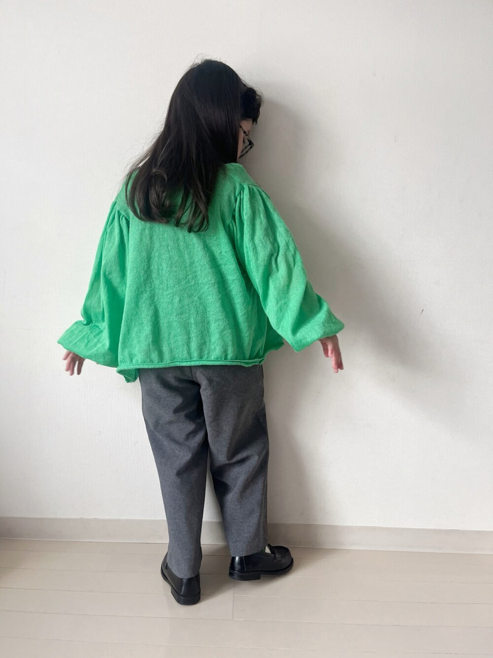 グレー系のワンピース、グリーン系のカーディガン/ボレロ、グリーン系のTシャツ/カットソーを着用したキッズの秋コーディネートの5枚目の写真