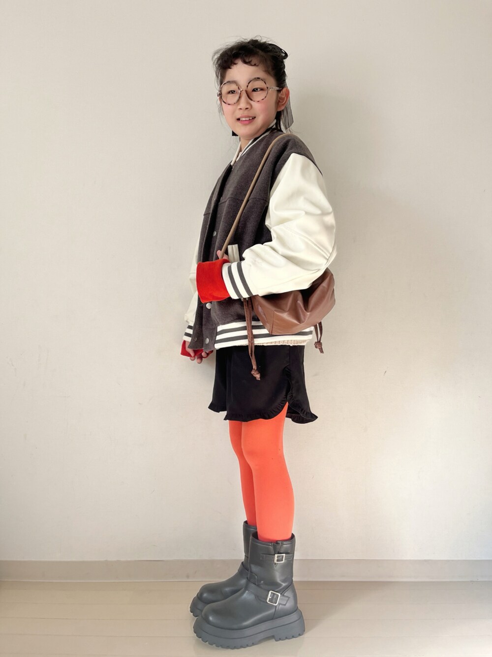 ホワイト系のニット/セーター、ホワイト系のTシャツ/カットソー、グレー系のスタジャンを着用したキッズの秋コーディネートの5枚目の写真