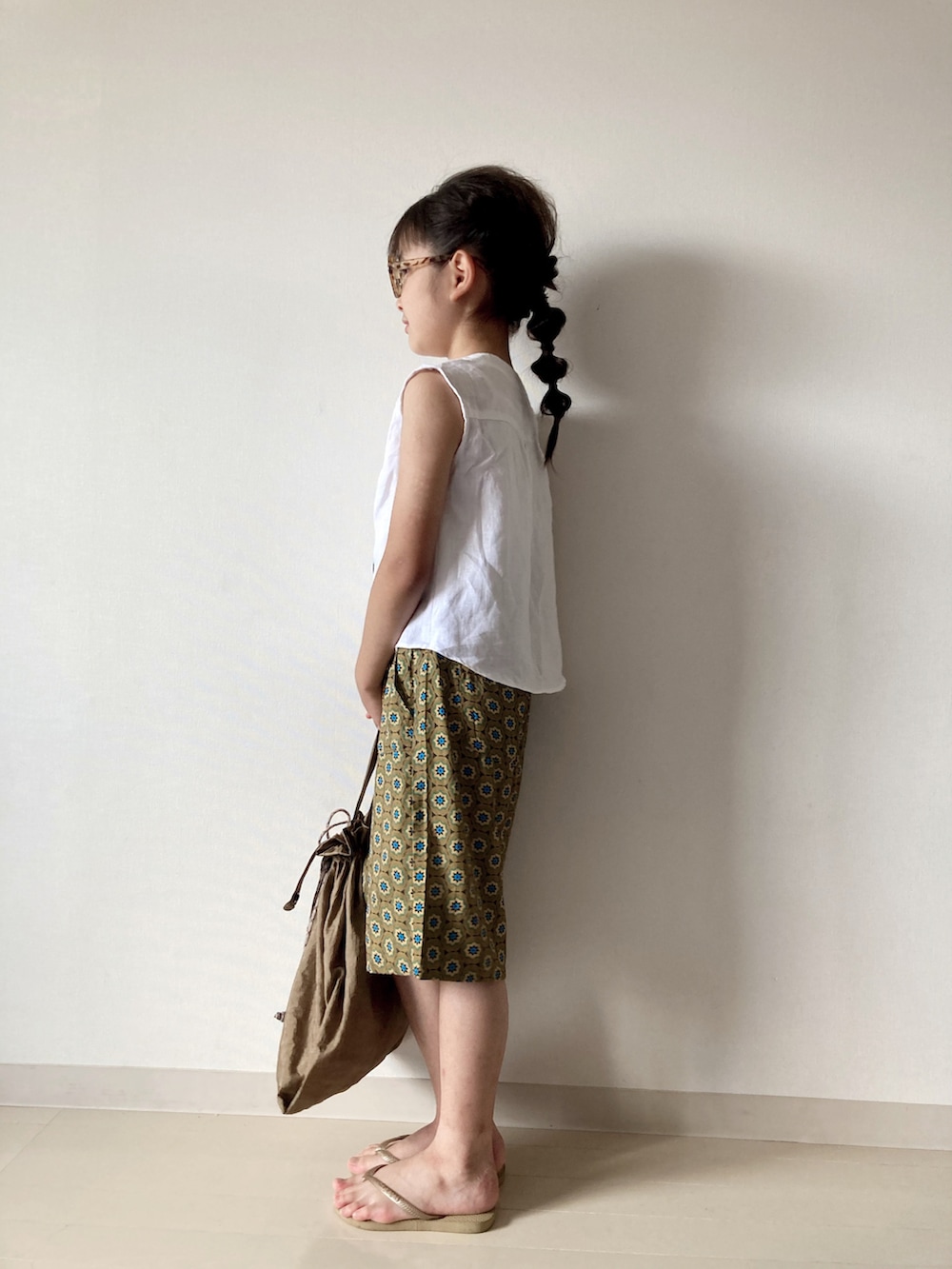 ベージュ系のその他パンツ、ホワイト系のシャツ/ブラウス、ベージュ系のビーチサンダルを着用したキッズの夏コーディネートの3枚目の写真