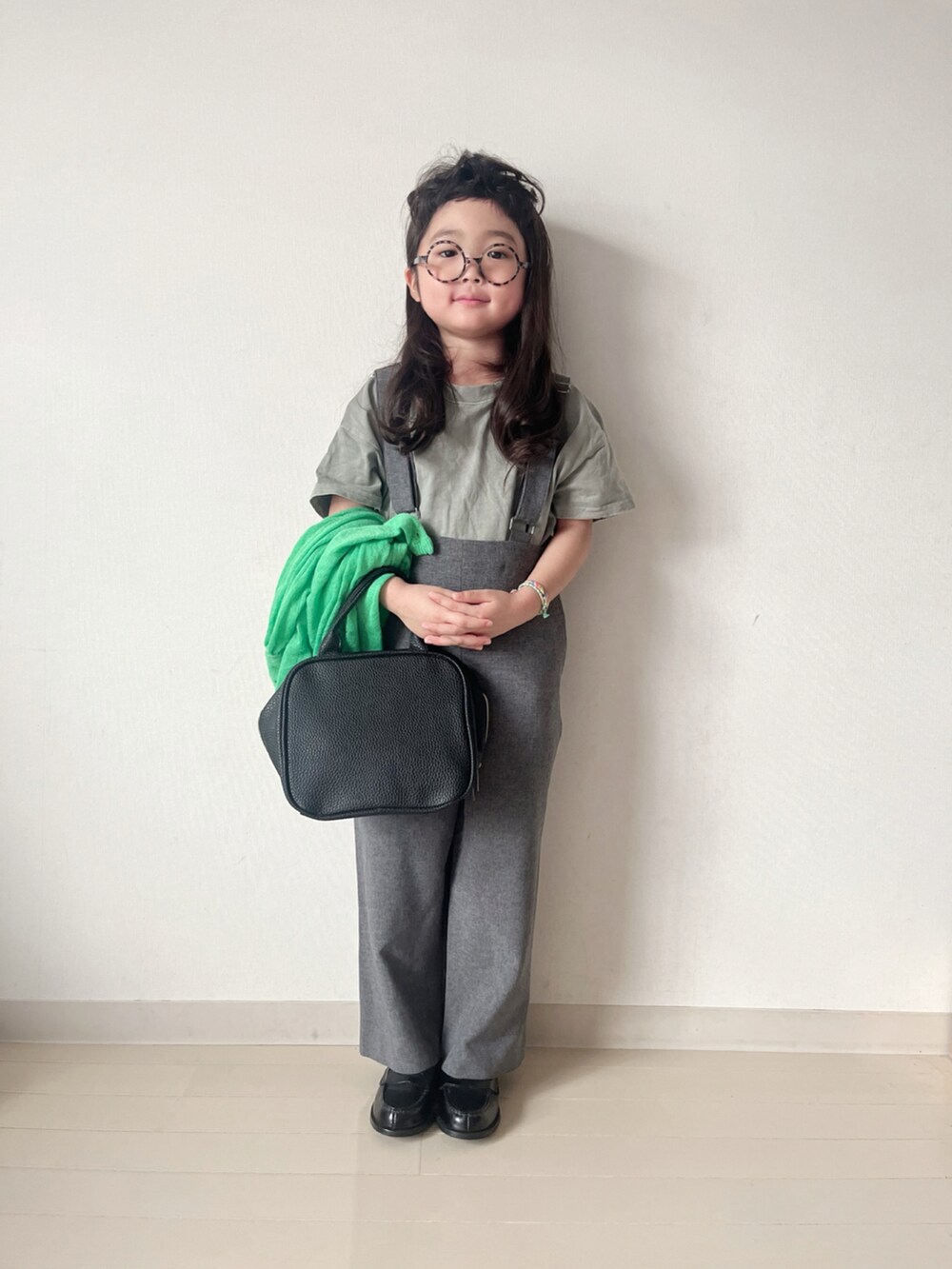 グレー系のワンピース、グリーン系のカーディガン/ボレロ、グリーン系のTシャツ/カットソーを着用したキッズの秋コーディネートの2枚目の写真