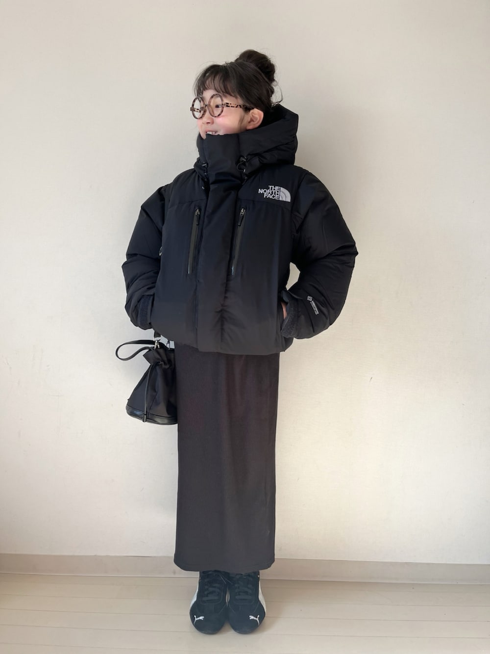 ブラック系のダウンジャケット/コート、ブラック系のスカート、ベージュ系のニット/セーターを着用したキッズの冬コーディネートの3枚目の写真