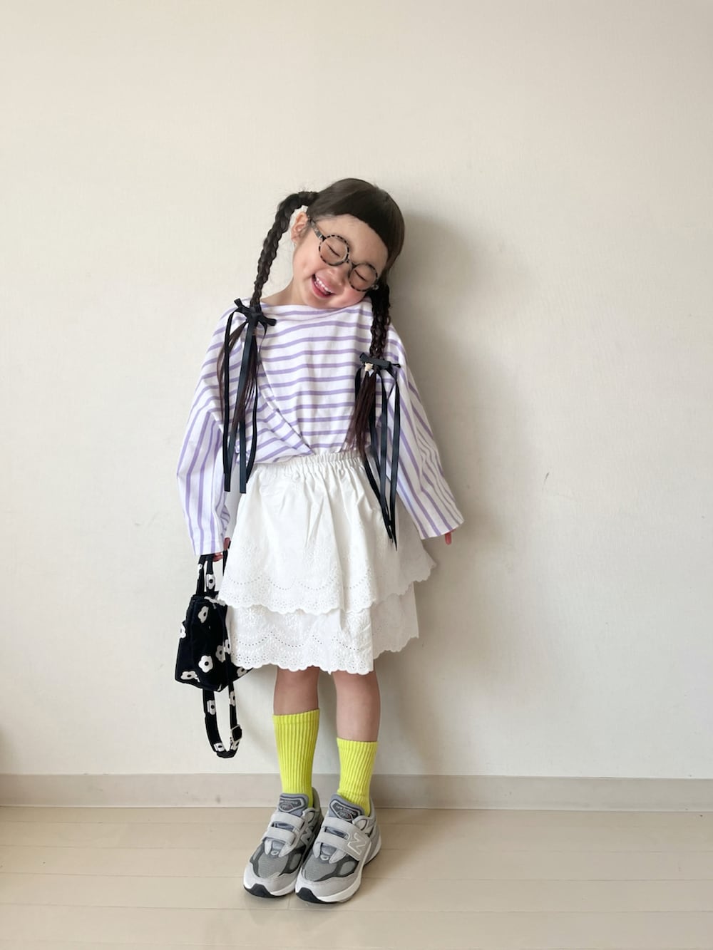 パープル系のTシャツ/カットソー、ホワイト系のスカート、ブラック系のショルダーバッグを着用したキッズの春コーディネートの3枚目の写真