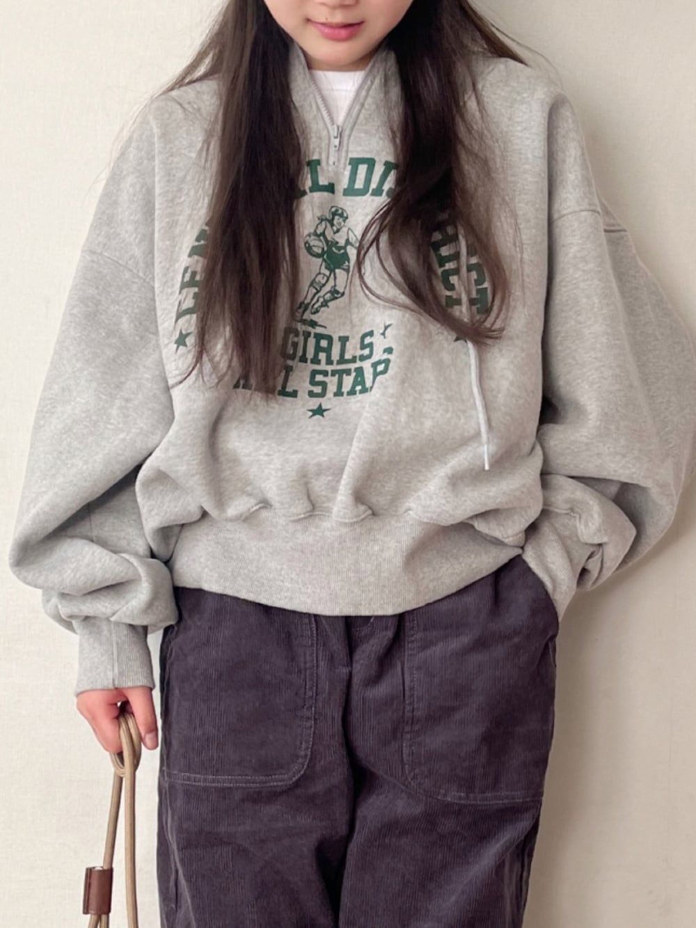 グレー系のスウェット、グレー系のその他パンツ、ブラウン系のショルダーバッグを着用したキッズの冬コーディネートの2枚目の写真