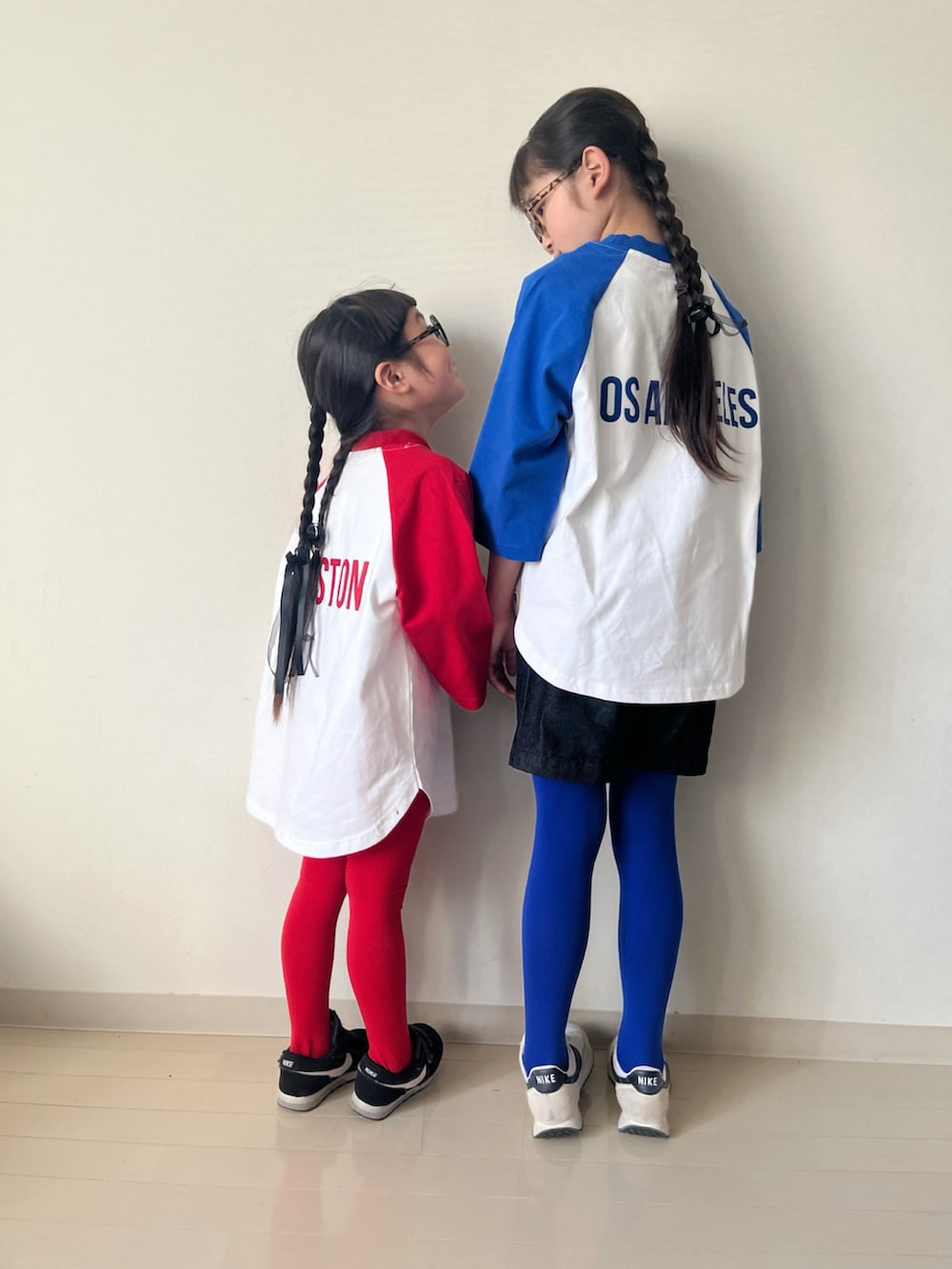 レッド系のTシャツ/カットソー、グリーン系のスカート、ブラック系のデニムパンツを着用したキッズの冬コーディネートの5枚目の写真