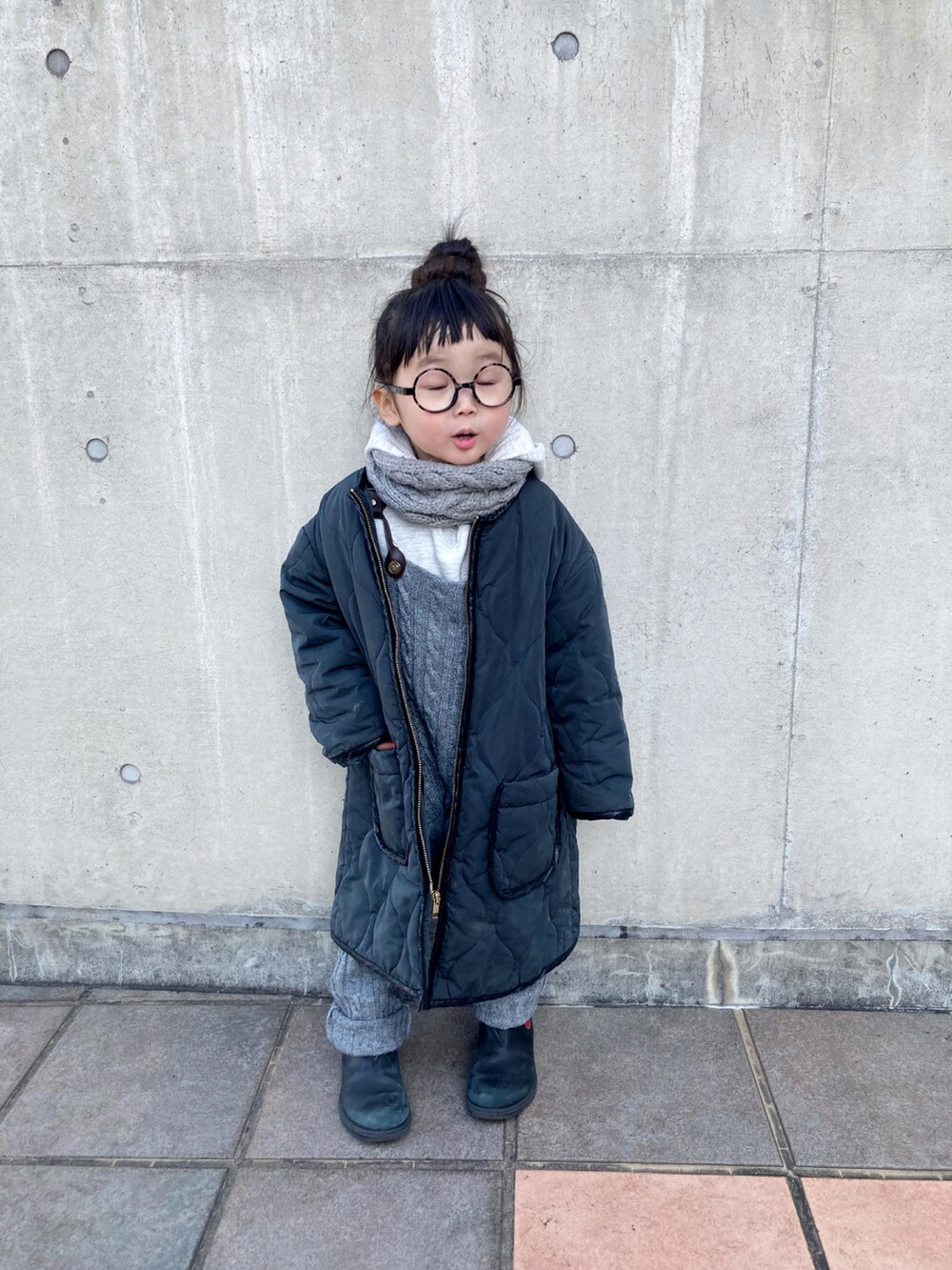 レッド系のブーツ、グレー系のサロペット/オーバーオール、ブラック系のニット/セーターを着用したキッズの冬コーディネートの4枚目の写真