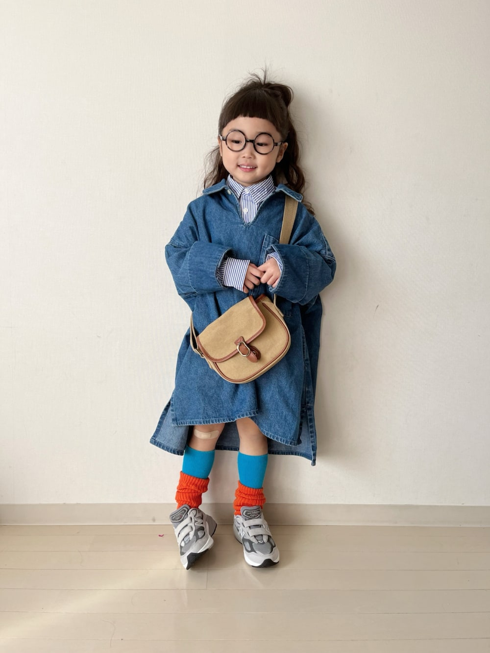 ブルー系のワンピース、ブルー系のシャツ/ブラウス、ベージュ系のショルダーバッグを着用したキッズの冬コーディネートの2枚目の写真