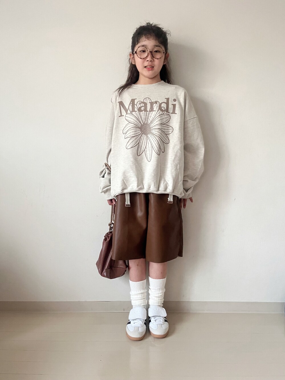 ベージュ系のスウェット、グリーン系のTシャツ/カットソー、ブラウン系のショルダーバッグを着用したキッズの秋コーディネートの4枚目の写真